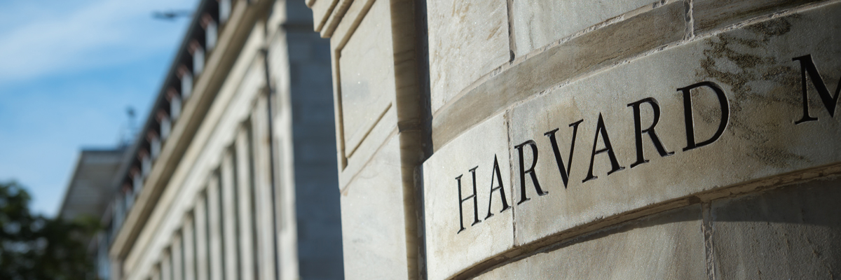 Harvard Medical School stone building focused on the engraved word Harvard with background out of focus.