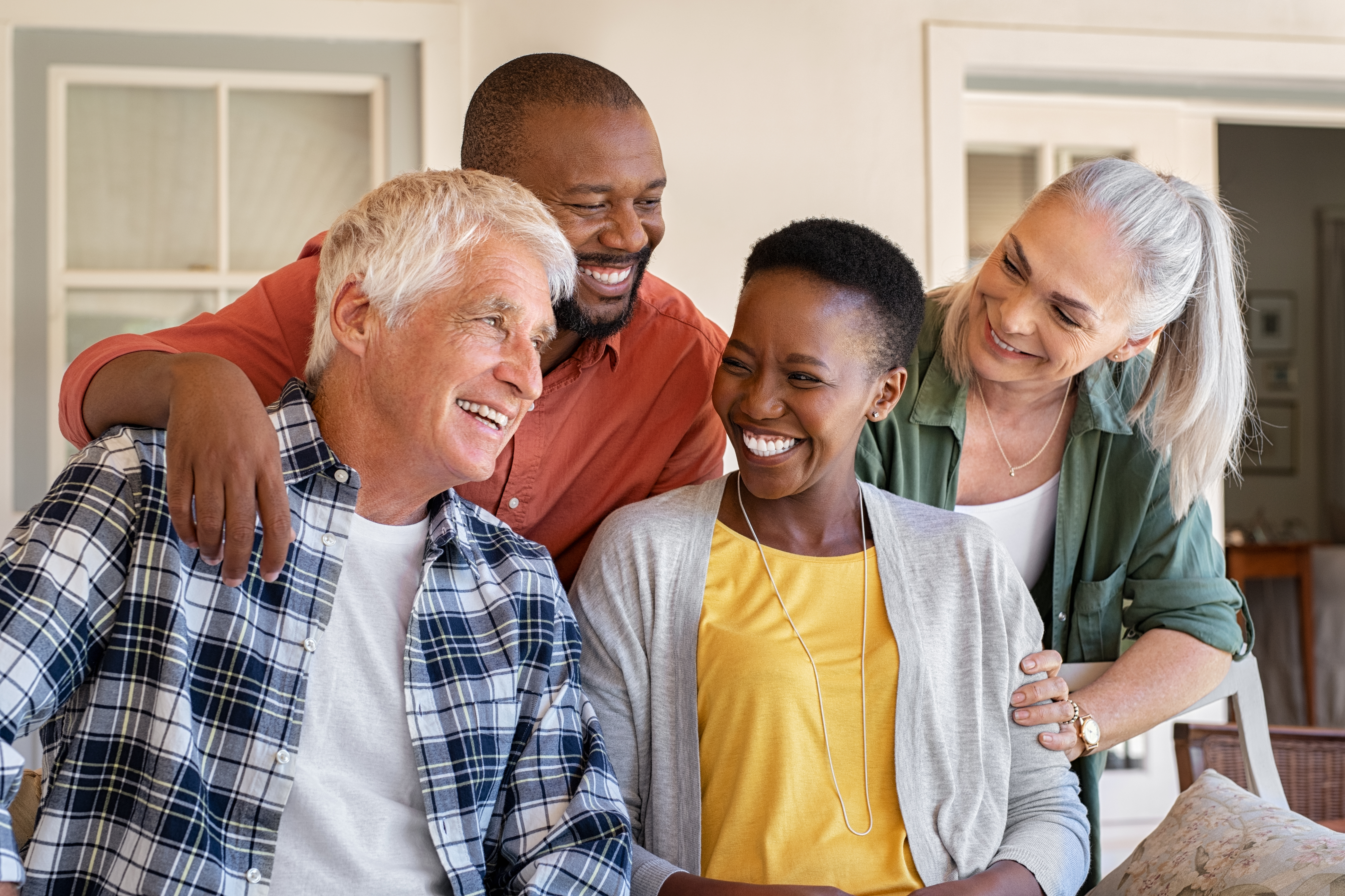 Four older people smiling at eachother.