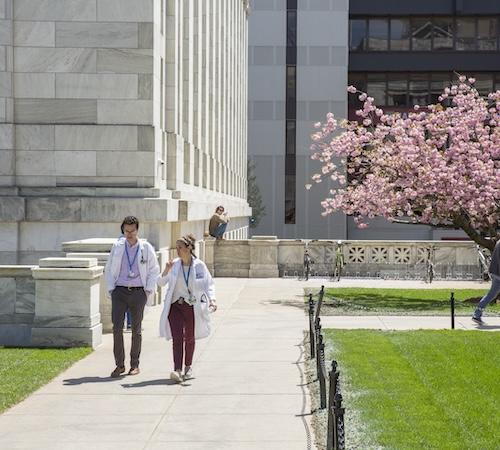 Two medical students walking on the quad.